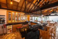 un ristorante con bar con sedie e tavoli in legno di Keramas Moonlight Villa a Keramas