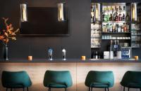 a bar with green chairs in a restaurant at Leonardo Hotel Salzburg Airport in Salzburg