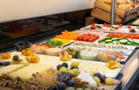 a buffet with many different types of cheese and vegetables at Leonardo Hotel Salzburg Airport in Salzburg