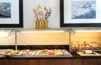 a buffet line with many different types of food at Leonardo Hotel Salzburg Airport in Salzburg