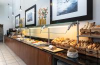 a buffet line with bread and pastries at Leonardo Hotel Salzburg Airport in Salzburg