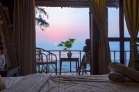 a bedroom with a bed and a view of the ocean at Woodpegger By The Beach, Mandrem in Mandrem