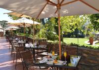 an outdoor restaurant with tables and chairs with umbrellas at Valley Lodge & Spa in Magaliesburg