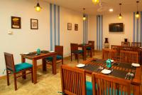 una sala da pranzo con tavoli e sedie in legno di Wisdom Boutique Resort a Kandy