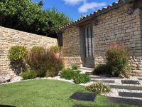 a garden with a stone wall and a door at Villa Pigouille in Sainte-Marie-de-Ré