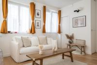 a living room with a white couch and a table at Beautiful duplex on the outskirts of Paris - Welkeys in Levallois-Perret