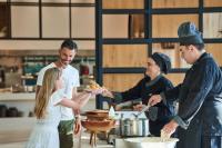 Un grupo de personas de pie en una cocina sosteniendo un plato de comida. en Agapi Beach Resort Premium All Inclusive, en Amoudara Herakliou