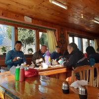 Un grupo de personas sentadas en una mesa comiendo en Sherpa Panorama Hotels, en Khumjung