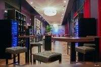 Una sala de cata de vinos con mesas y taburetes de bar. en La Souveraine, en Contrexéville