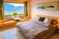 Un dormitorio con una cama grande y una ventana grande. en 云起山居庭院观景民宿, en Fenghuang