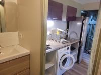 a small kitchen with a washing machine and a sink at studio 27m2 in Quissac