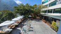 an outdoor patio with tables and chairs and umbrellas at Tangyue Resort in Tai&#39;an