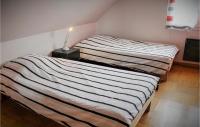 two beds sitting next to each other in a room at Awesome Home In Plougonvelin With Private Swimming Pool, Can Be Inside Or Outside in Plougonvelin