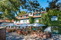 宾茨Oma's Küche & Quartier的建筑物前有桌子和遮阳伞的露台