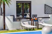 a patio with chairs and a table next to a pool at Skiathos Holiday Resort in Skiathos