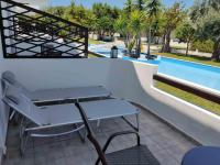 a table and a bench next to a swimming pool at Skiathos Holiday Resort in Skiathos