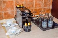 a coffee maker on a counter with cups and saucers at Skiathos Holiday Resort in Skiathos