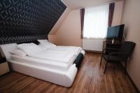 1 dormitorio con cama blanca, escritorio y ventana en Vidéki vendégház a Bükkben, pezsgőfürdővel., en Királd