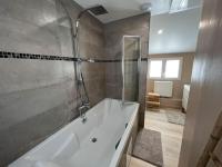 a large bathroom with a tub and a shower at Maison cocooning Porcheville 
