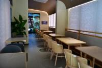 uma fileira de mesas e cadeiras em um restaurante em Xishu Garden Inn - Travel Agency service - Car Rent service - English Speaking em Chengdu