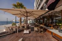 a restaurant with tables and chairs and a large umbrella at ERTAN OTEL in Cesme