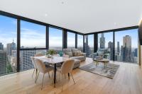 Una sala de estar con un sofá, una mesa y sillas. en Collins House Apartments by CLLIX, en Melbourne