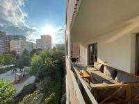 a balcony with a couch and a view of a city at Magnifique logement avec terrasse &amp; climatisation in Aubervilliers