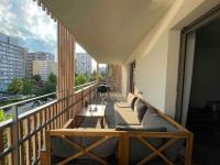 a balcony with couches and tables on a building at Magnifique logement avec terrasse &amp; climatisation in Aubervilliers