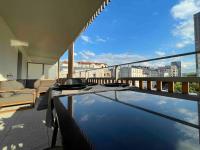 a balcony with a table and a view of a city at Magnifique logement avec terrasse &amp; climatisation in Aubervilliers