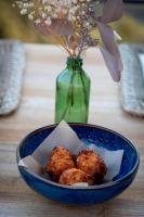 una ciotola blu di cibo su un tavolo con un vaso di Hôtel Case Latine a Lama