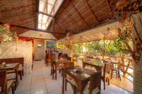 ein Esszimmer mit Tischen, Stühlen und Fenstern in der Unterkunft Pousada das Galinhas in Porto De Galinhas