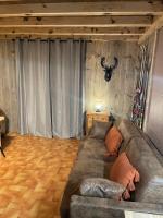 a living room with a gray couch and a wooden floor at APPARTEMENT PLEIN SUD AUX SAISIES N°6 in Les Saisies