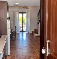 a kitchen with a tiled floor and a hallway with a door at Skiathos Holiday Resort in Skiathos