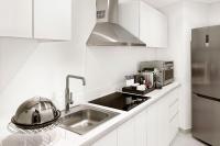 a white kitchen with a sink and a microwave at Sheraton Abu Dhabi Hotel & Resort in Abu Dhabi