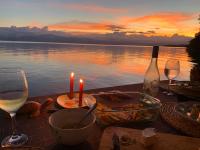a table with wine glasses and food and a candle at Ponci’s Gate to Gaia Holistic Center in Bocas del Toro