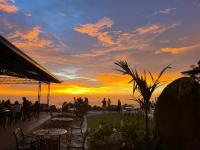 a group of people sitting at tables watching the sunset at Kokol Haven Resort in Kota Kinabalu
