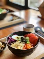 uma tigela preta de comida numa mesa de madeira em Wudang Mountain Manju Manor em Wudangshan
