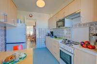 eine Küche mit weißen Schränken und einem Herd mit Backofen in der Unterkunft Appartement Le Fabiola - Happy Rentals in Antibes