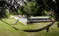 a hammock in a yard with a swimming pool at Une pause en Corrèze in Sarroux
