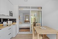 a kitchen with a table and a room with a bed at Studio Sunshine in Le Diamant