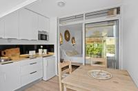 a kitchen and dining room with white cabinets and a table at Studio Sunshine in Le Diamant