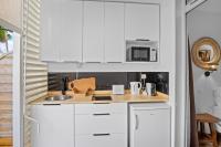 a kitchen with white cabinets and a sink at Studio Sunshine in Le Diamant