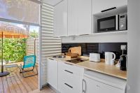 a kitchen with white appliances and a patio with a table at Studio Sunshine in Le Diamant