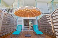 two blue chairs and an umbrella on a deck at Studio Sunshine in Le Diamant