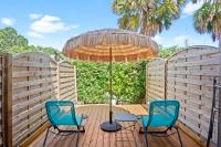 two chairs and an umbrella on a wooden deck at Studio Sunshine in Le Diamant