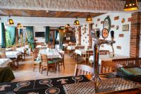 a dining room with tables and chairs in a restaurant at Paleus Resort in Oradea