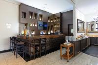 a bar in a restaurant with a counter and stools at Faro Hotel Taubaté in Taubaté
