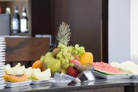 a bunch of fruits on a table with wine bottles at Faro Hotel Taubaté in Taubaté