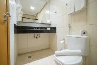 a bathroom with a white toilet and a sink at Faro Hotel Taubaté in Taubaté