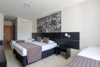 a hotel room with two beds and a wall at Faro Hotel Taubaté in Taubaté